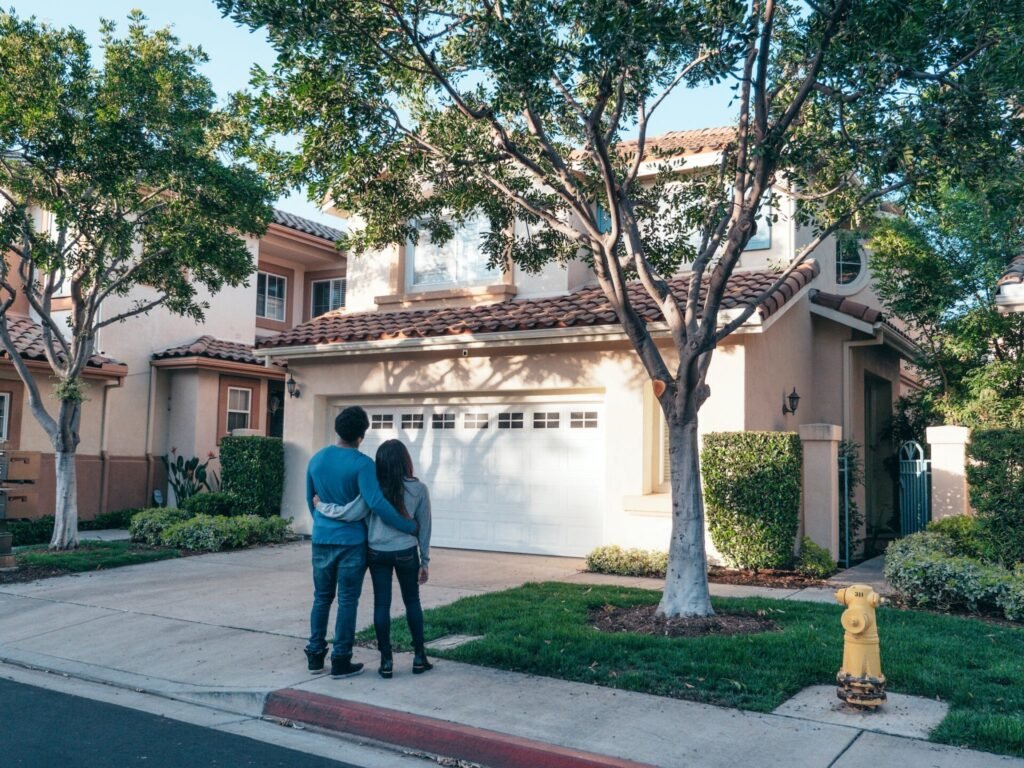 Couple Standing In Front of their House : Property Advertising Tactics in Real Estate Marketing